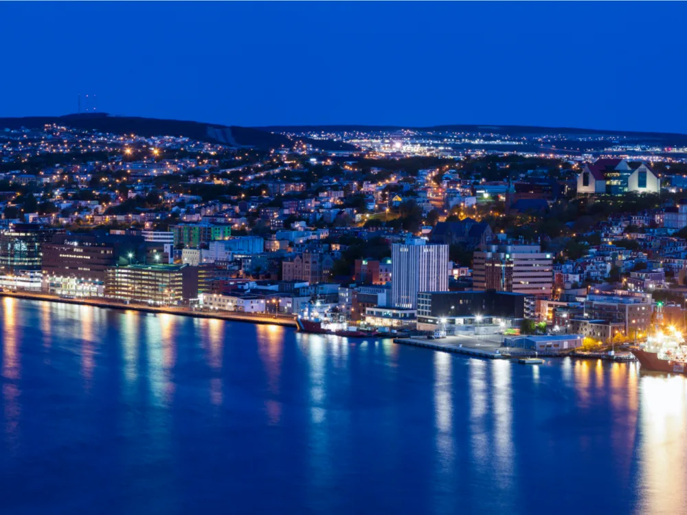 Aerial view of beautiful nightlight of St. John's, Newfoundland and Labrador, one of the best places to visit in Canada, reflected on calm waters