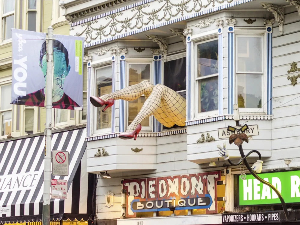 A sculpture on a pair of large legs wearing fishnet stockings and red heels out of a window at Haight-Ashbury, a hippy neighborhood and one of the best places to visit in San Francisco