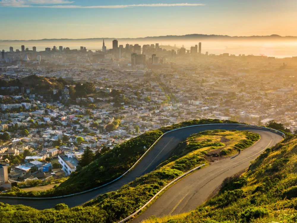 Sweet sunrise over curve narrow sloppy road atop Twin Peaks, one of the best places to visit in San Francisco, Downtown