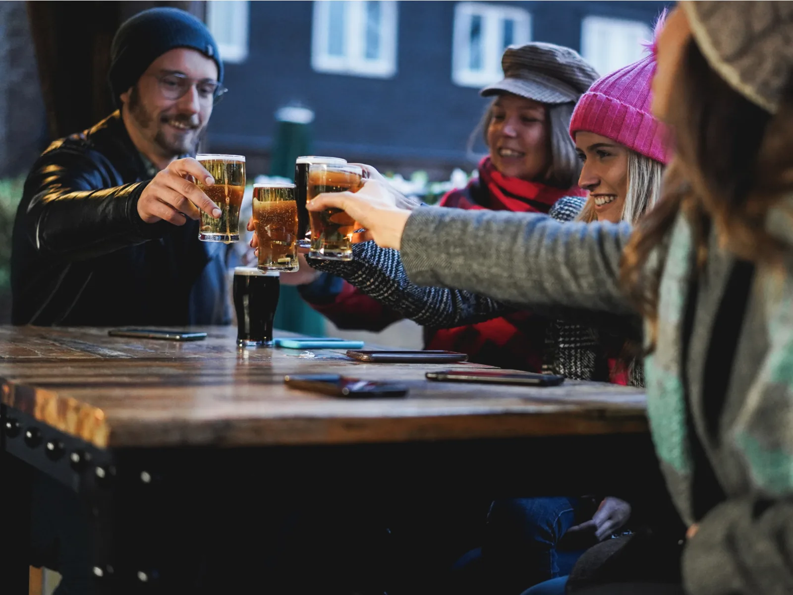 A happy group of friends toasting beer at a pub, one of the best places to visit in Ireland