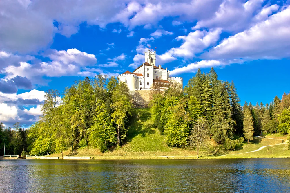 Trakoscan Castle in Zagorje, a top pick for must-visit places in Croatia, pictured on a blue-sky day with a few clouds overhead