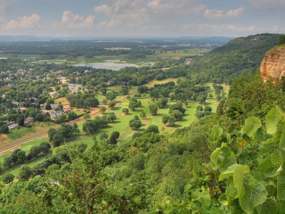 View atop Grandad Bluff, one of the best Wisconsin tourist attractions, with green landscape and patches of trees from below