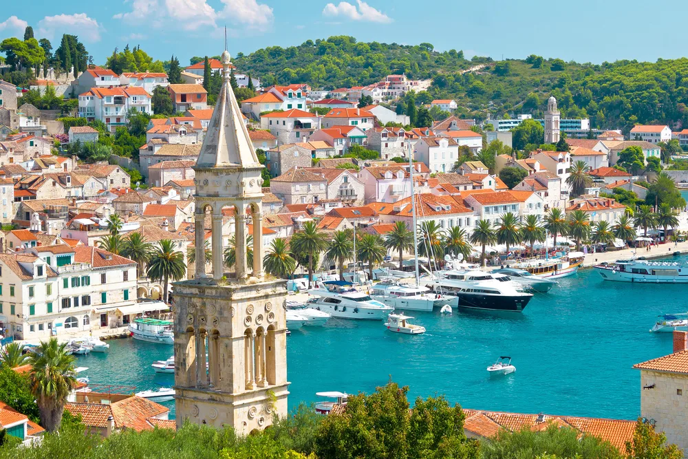 Amazing view of the Hvar harbor as seen from the air with still teal water in the bay on which expensive boats float