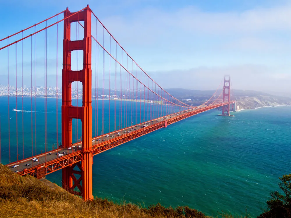 Cars traversing the international orange Golden Gate Bridge, named as one of the best places to visit in San Francisco, in both directions