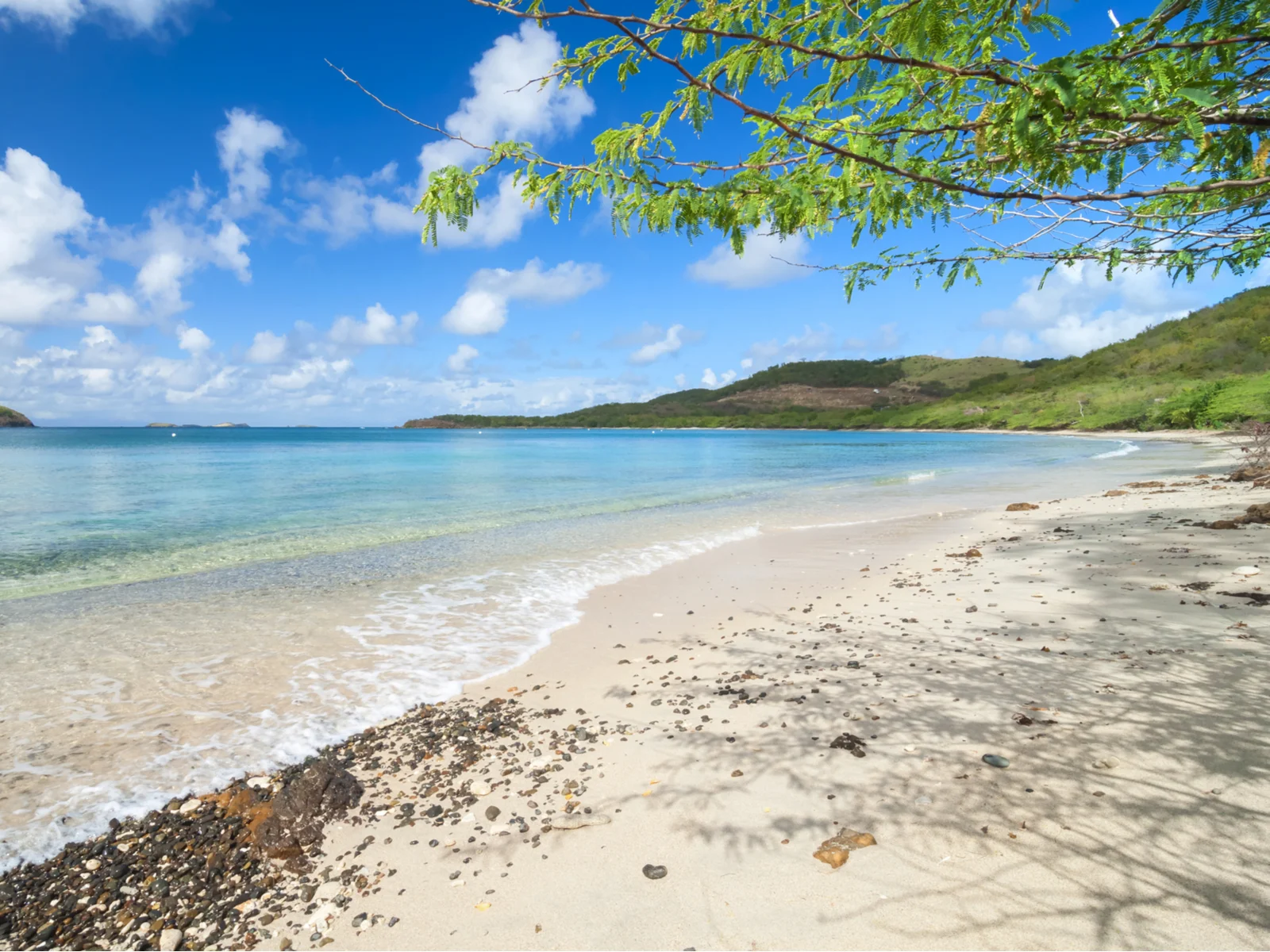 Tamarindo beach, a top pick for the best places to visit in Costa Rica, as seen from the shoreline looking into the ocean on a sunny day