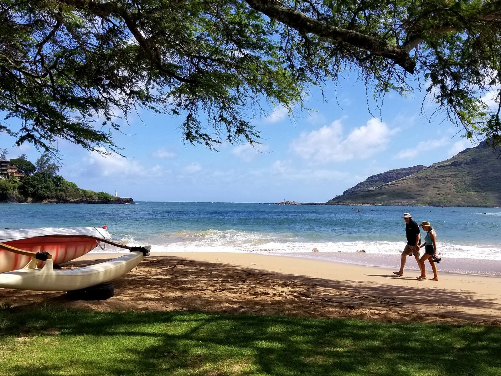 A couple barefoot while walking along the shore of Kalapaki Beach, one of the best beaches in Kauai