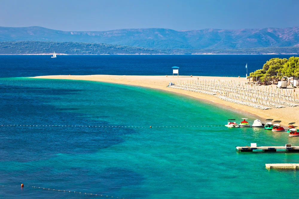 Famous island of Zlatni Rat, one of Croatia's best places to visit, pictured from the air with a tan sand beach jutting into the ocean